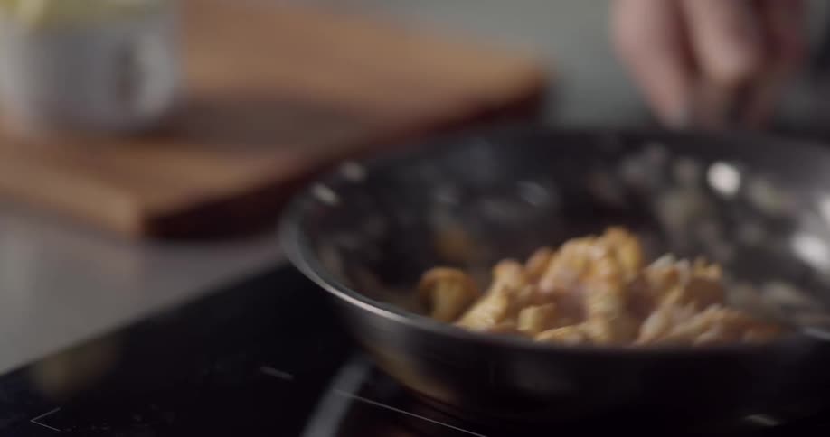Cauliflower being shaken and flipped in a skillet