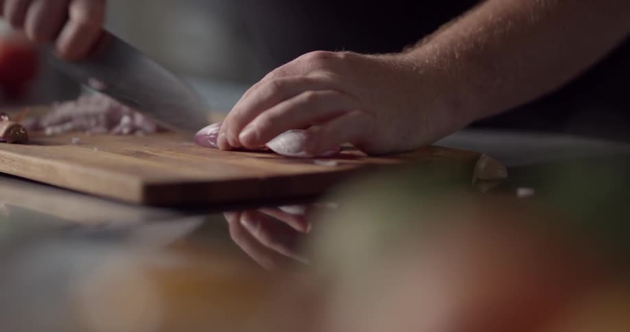 A person is cutting an onion on a cutting board