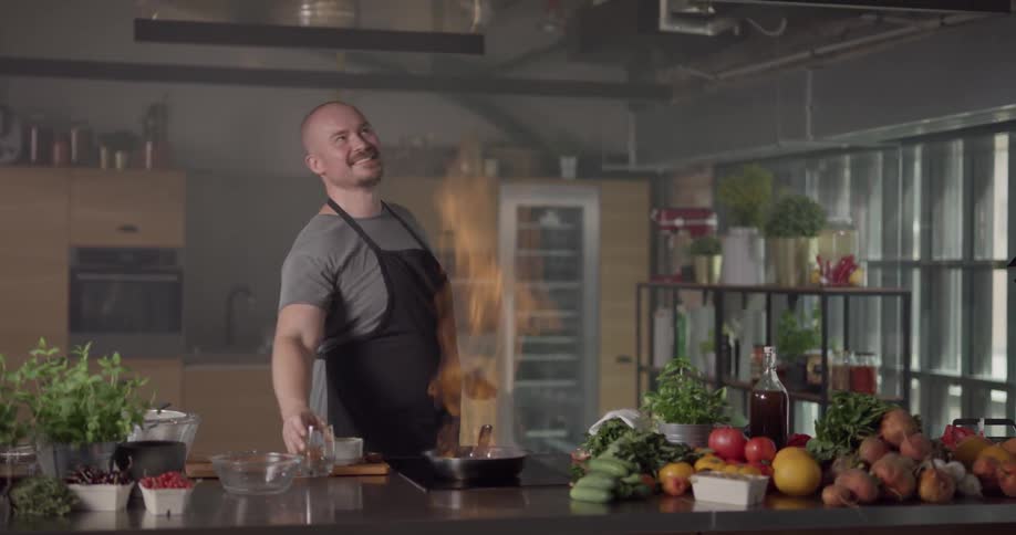 A chef pour alcohol into a pan and lights it on fire