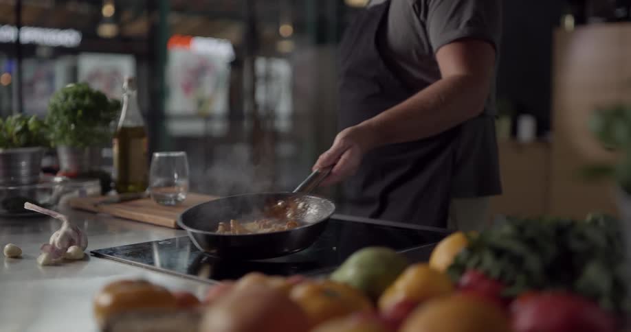 Man jiggles skillet on stove
