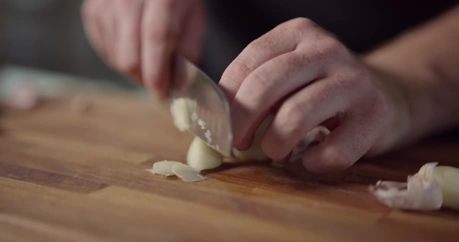 Food being sliced on a wooden cutting board