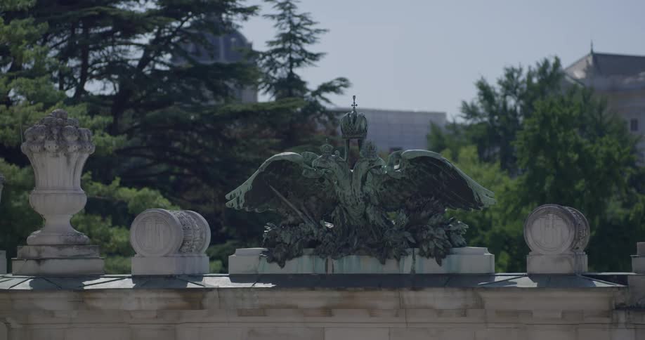 There is a statue sitting on the wall near the city