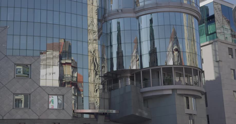 Scenery reflects on mirrored surface of building