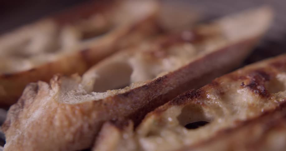 Slices of bread are toasting on a flat grill