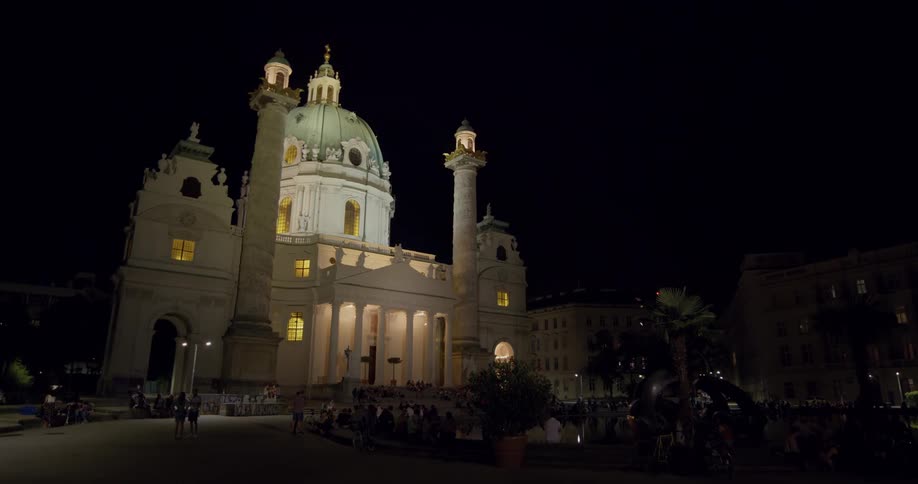 A white building at night time being lit up by lights