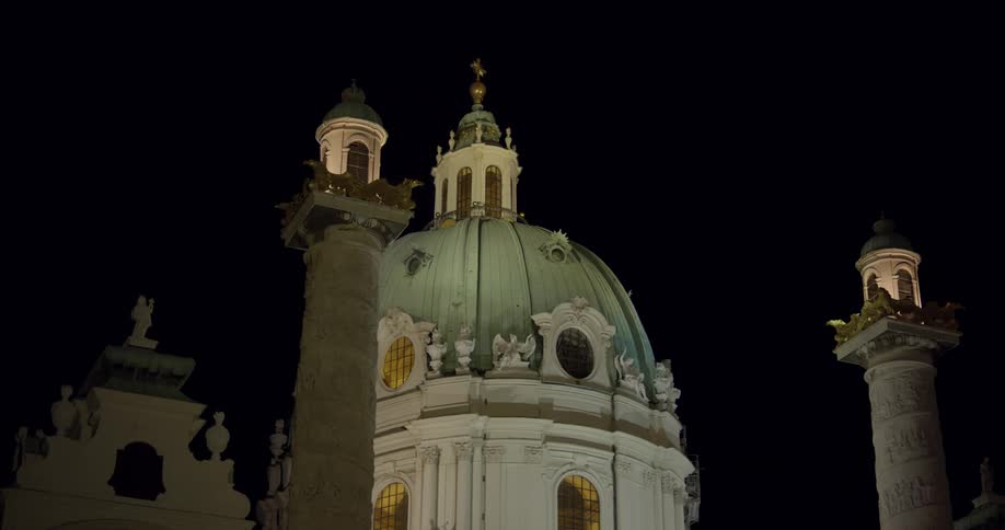 A gold and patina dome lit in the night sky