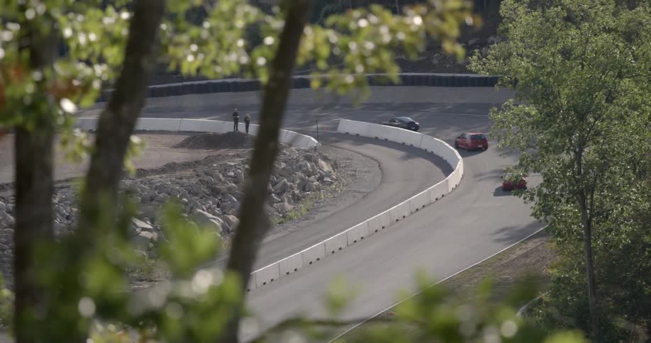 An elevated view of an active racetrack as seen from a hillside