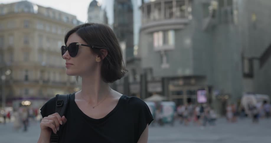 A woman looks around at a city