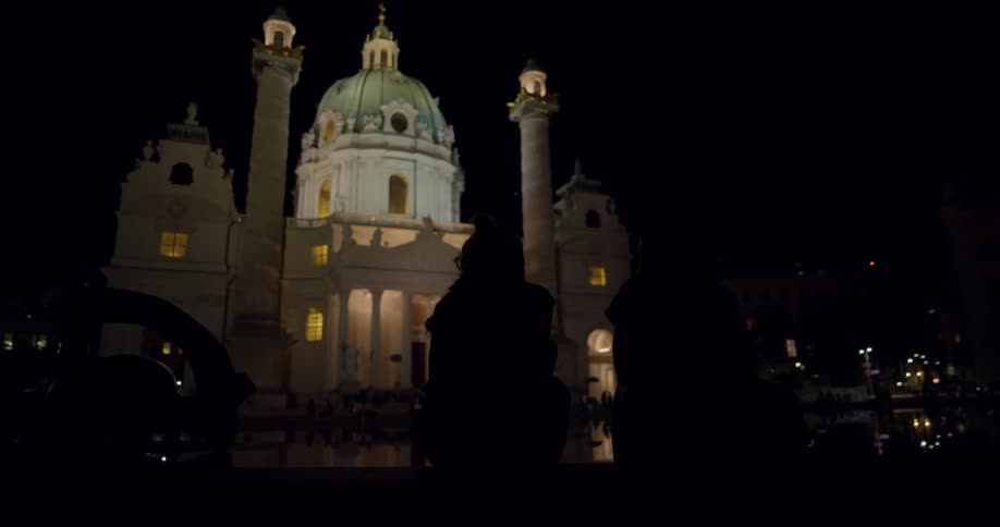A picturesque building with a dome and two towers are illuminated at nighttime to make a spectacular sightseeing destination