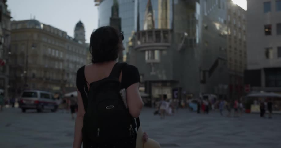 A woman is walking in a downtown area