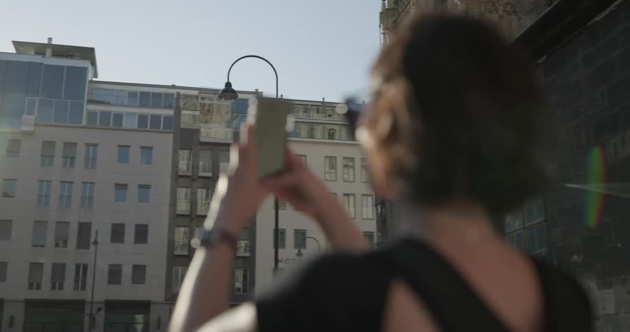 Woman photographs building with phone