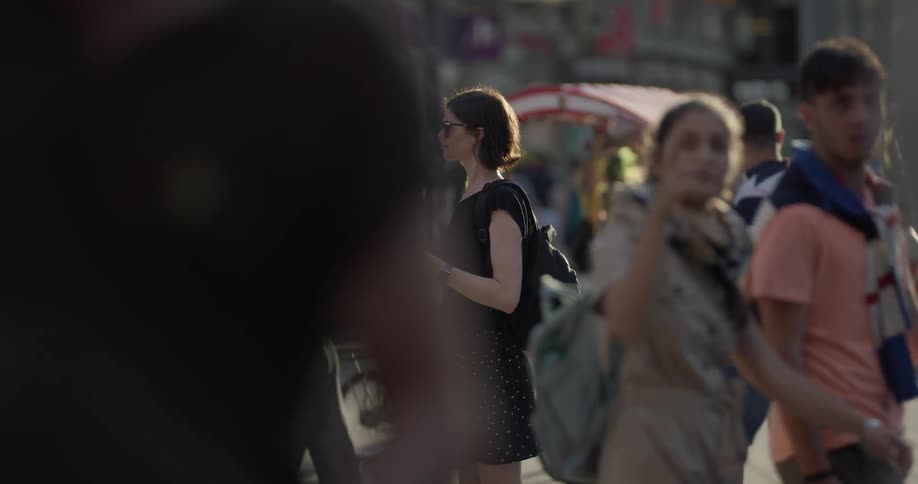 A young woman in a busy plaza takes a photo