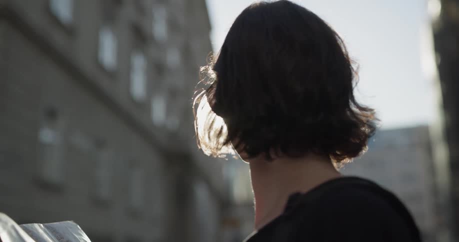 Woman wearing sunglasses reads a map at the city