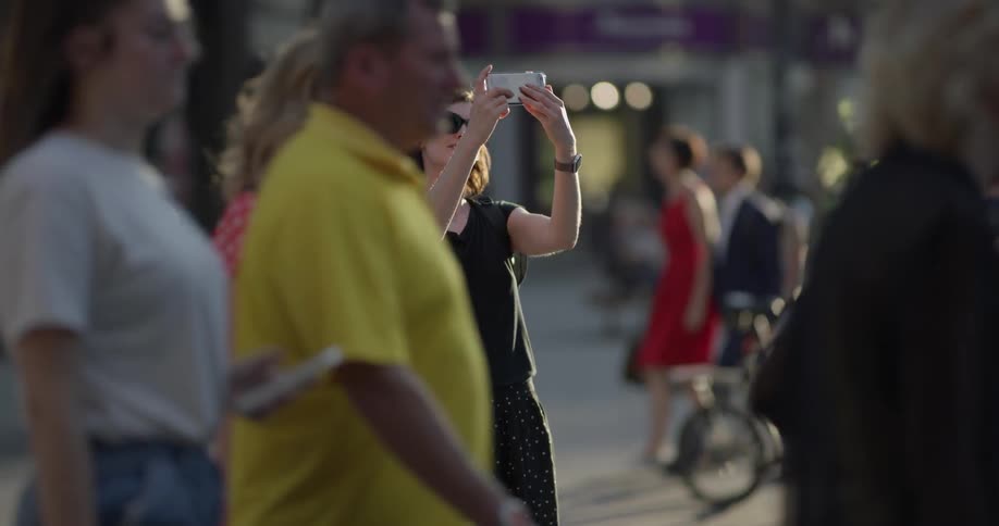 Woman filming herself with a smartphone on the streets