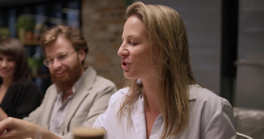People sit at a table eating and drinking and talking
