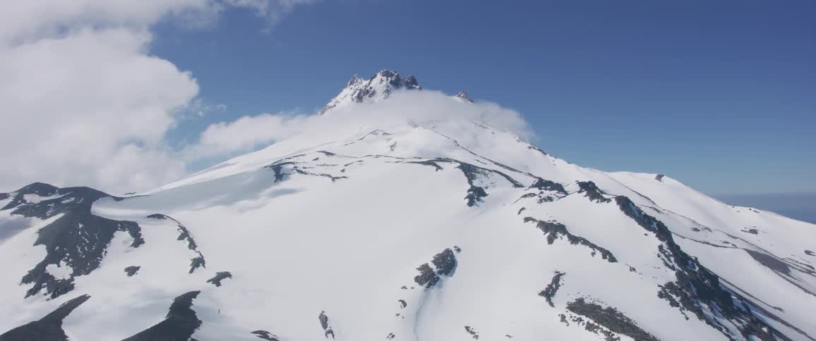 A snow covered mountain rises high above the surrounding area