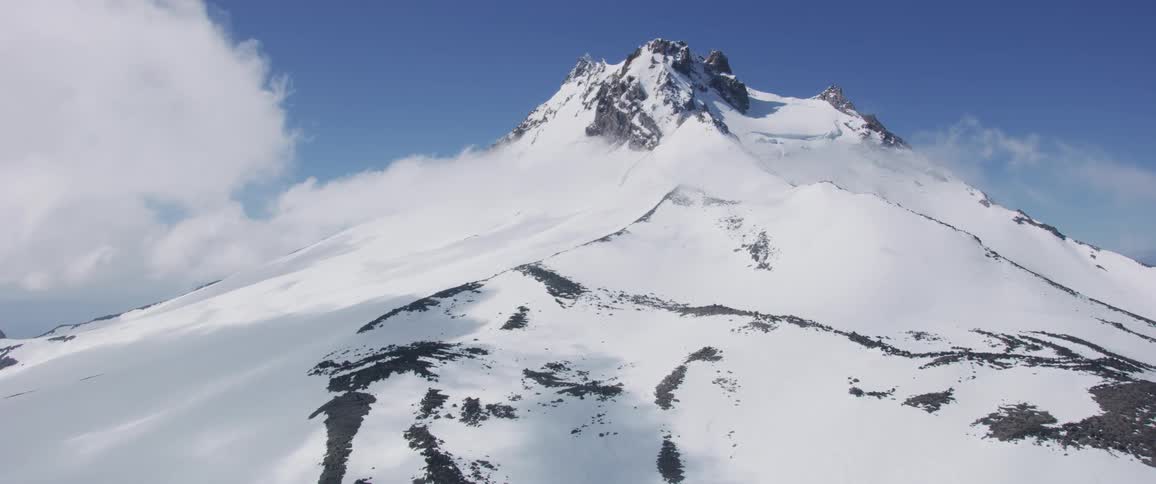 Landscape of the snow covered top mountain above the clouds in the daytime