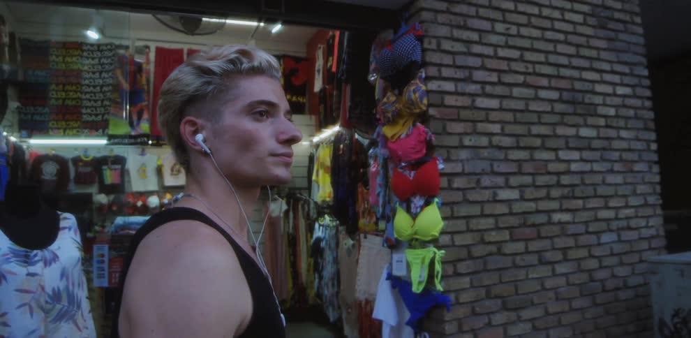 A man is walking in a city where stores are located