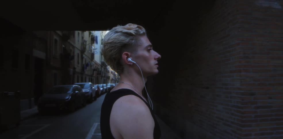 A young man walks along a city street