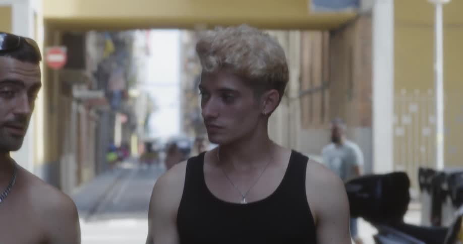 Man with dyed hair walks down the street in the neighborhood during daylight