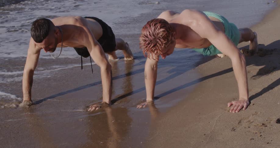 Two man push up on the white sand beach in the daytime