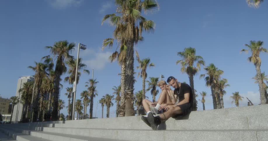 Two men sitting on a stone staircase outdoors during the day