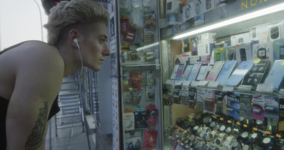 A young man looks at a display case on the street
