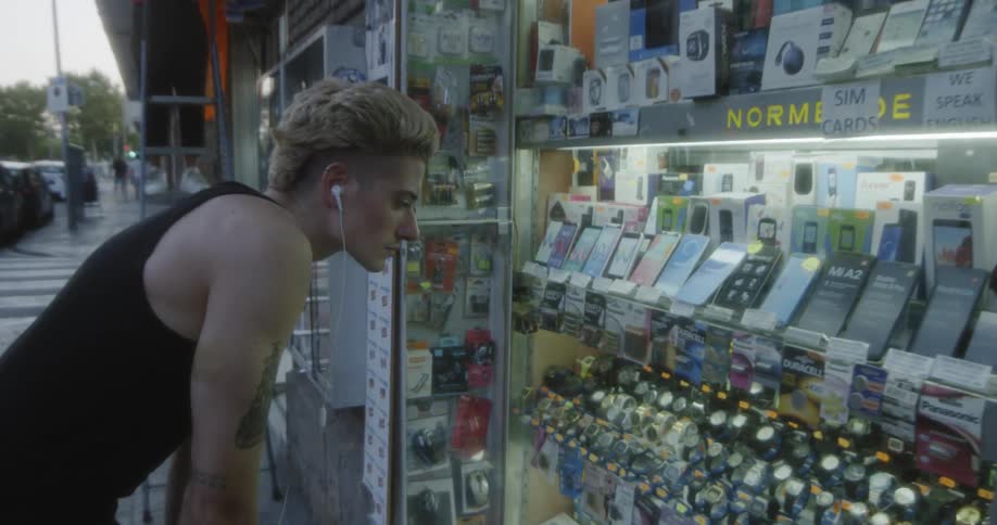 A young caucasian male outside window shopping for a watch