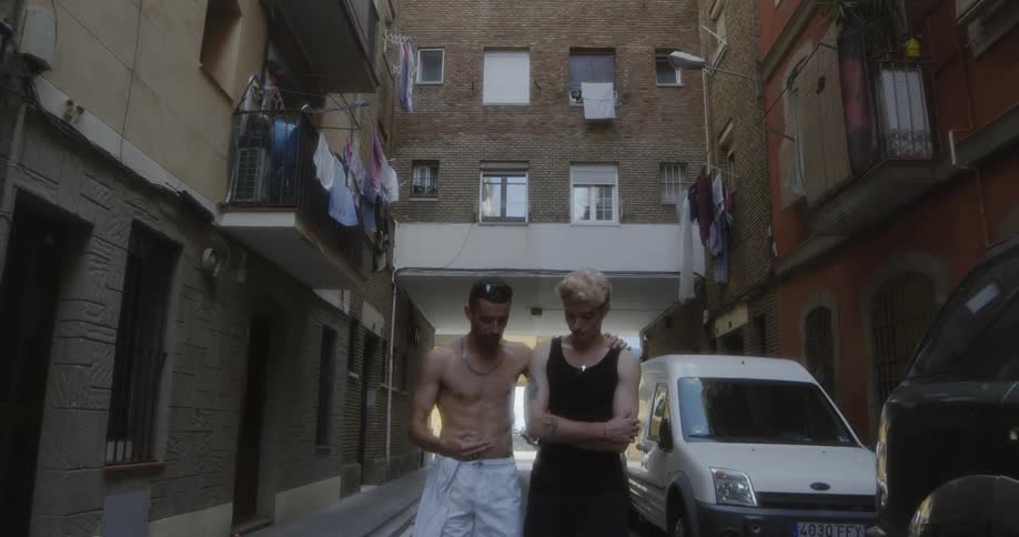 Two men walk down an alley together