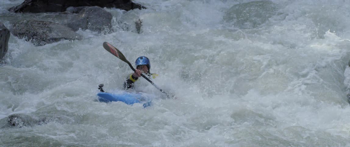 A man kayaking in river rapids