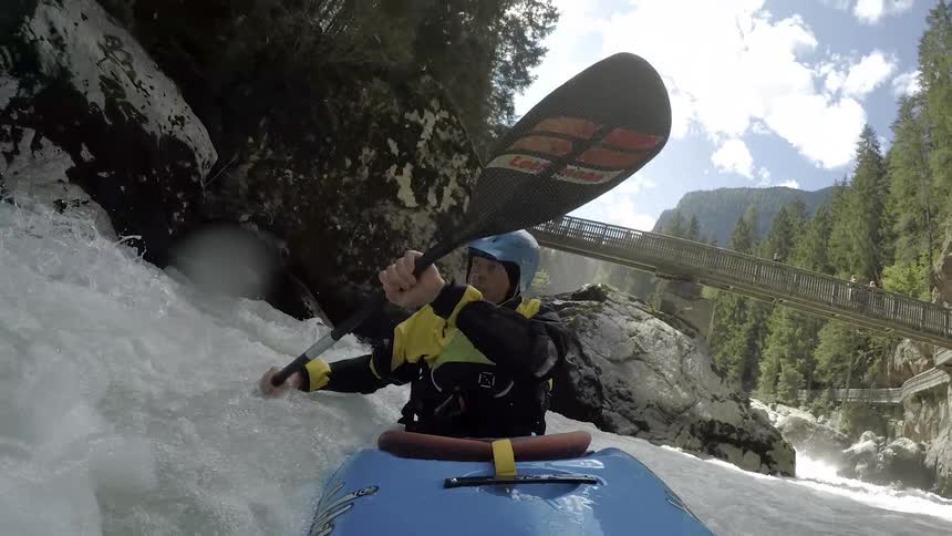 A kayaker paddles through turbulent waters filled with rocks