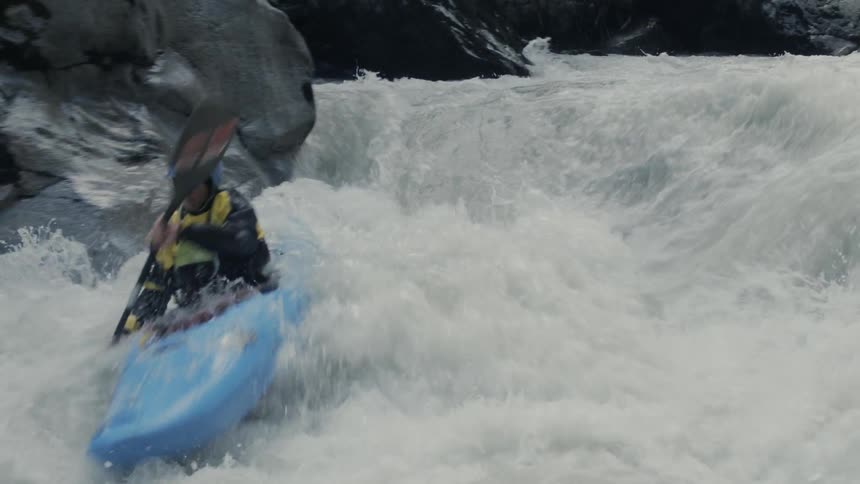 A person riding a kayak down white water rapids