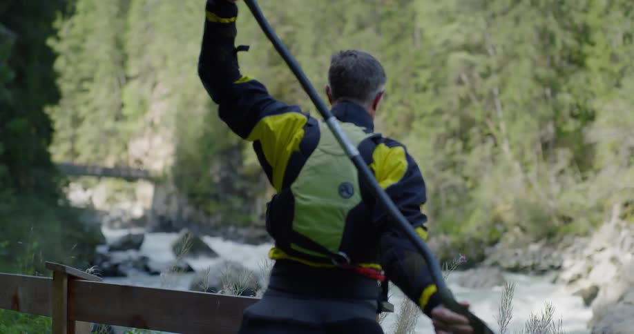 A canoeist during stretches near a wooden railing