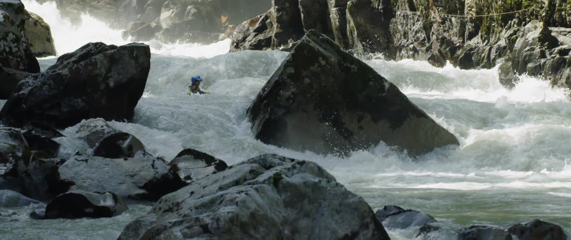 A person canoeing down white water rapids