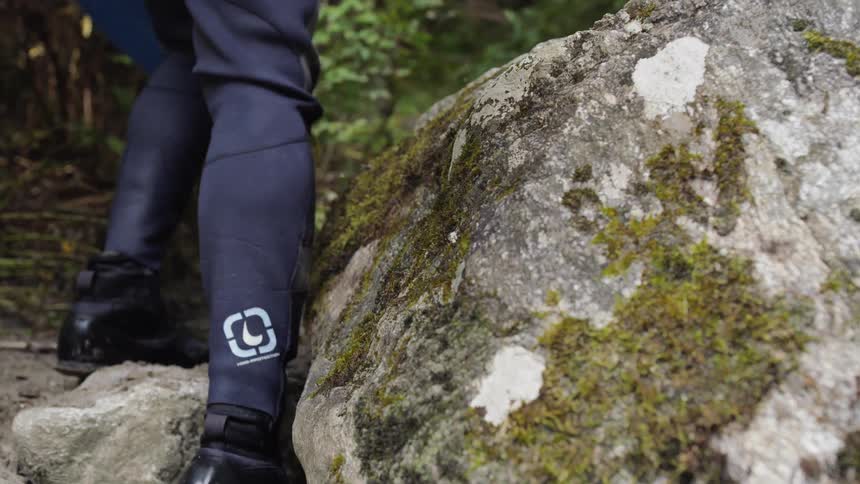 A person in a wet suit hikes up a trail
