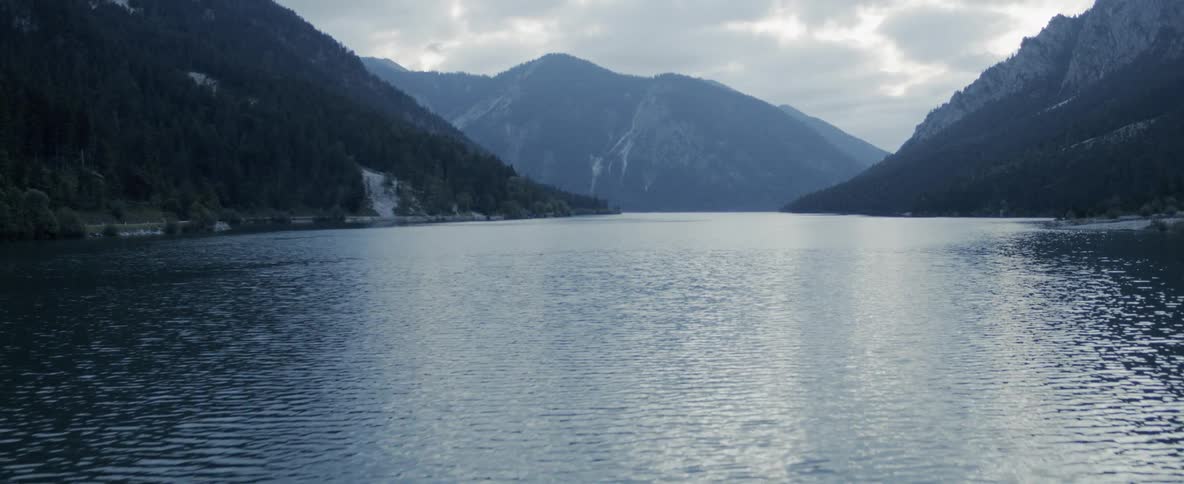 The camera flies across a mountain lake