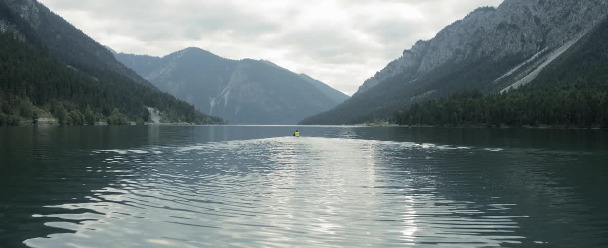 A person in a kayak paddles across a lake