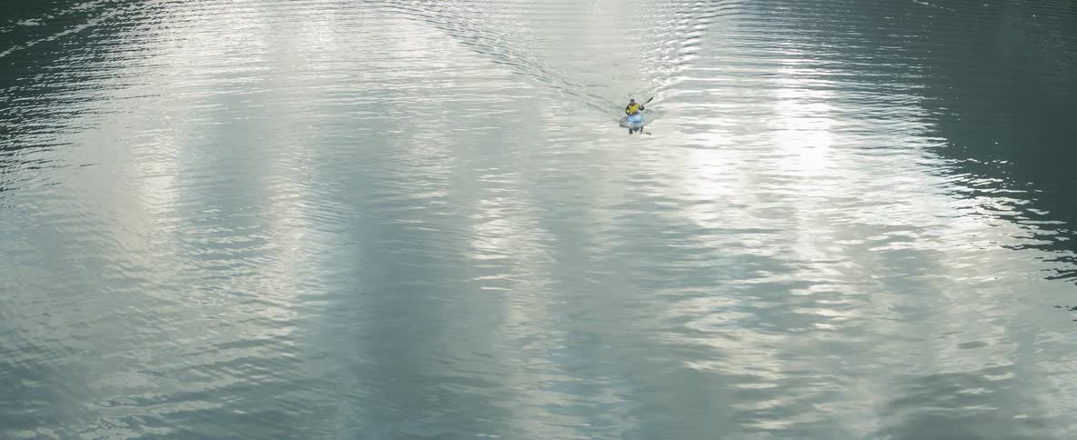A man kayaking on a large body of water