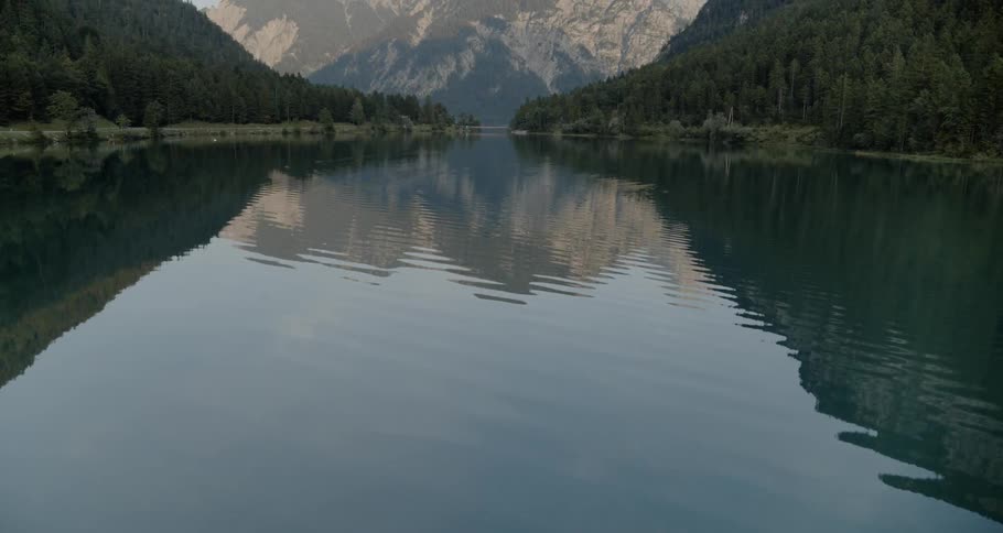 A river running through a forest and nearby mountains