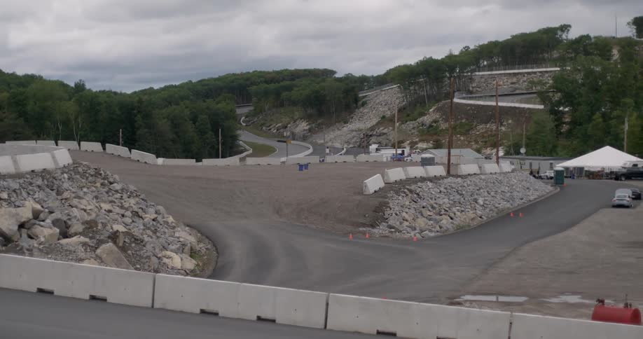 Cars pass a small runway on a hillside