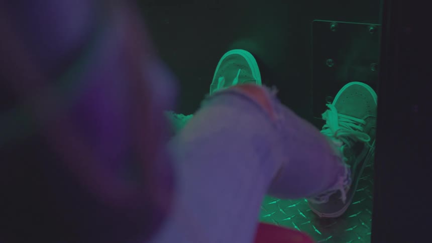 Close shot of a person's foot while playing an arcade game