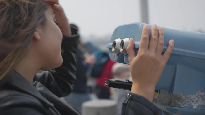 A woman looks through binoculars