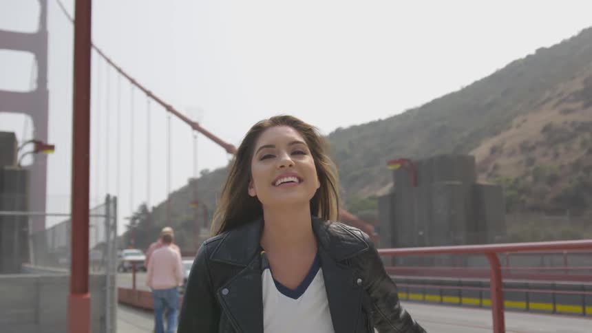 A woman smiles while walking around on the golden gate bridge