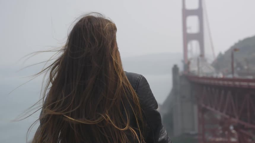 Girl standing next to a bridge