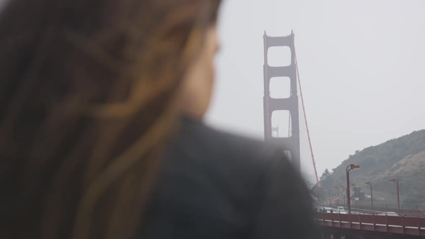A woman looks at the golden gate bridge