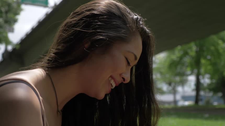 A woman is smiling outdoors