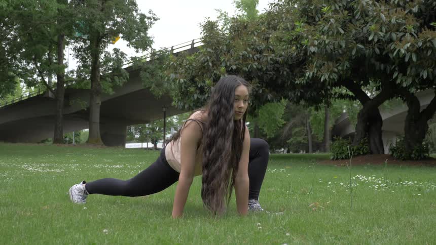 A woman is stretching outside