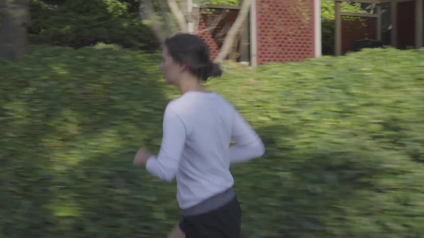 A young female jogging in a suburban street on a sunny day