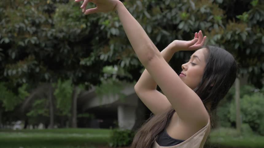 A woman doing yoga in a park