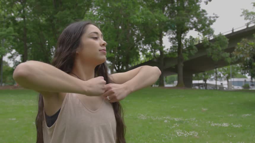 A woman practicing dance moves in a park during the day